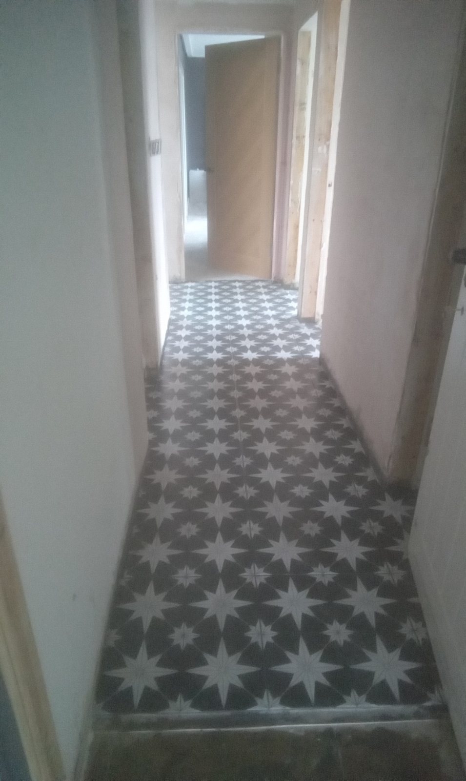 Completed grey and white patterned tiled hallway in Airdrie