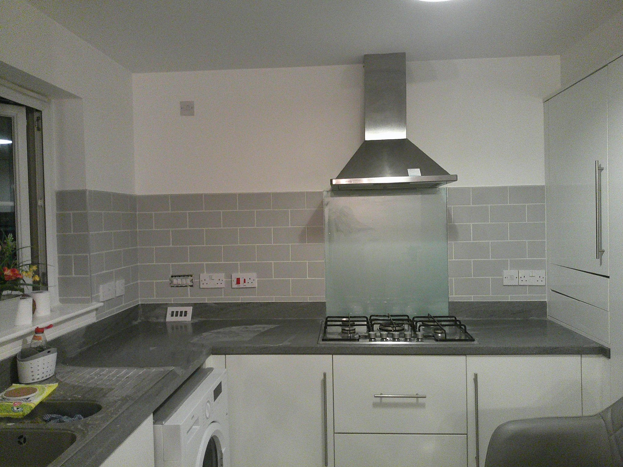 Completed grey brick-style kitchen splashback around the hob in Whitburn