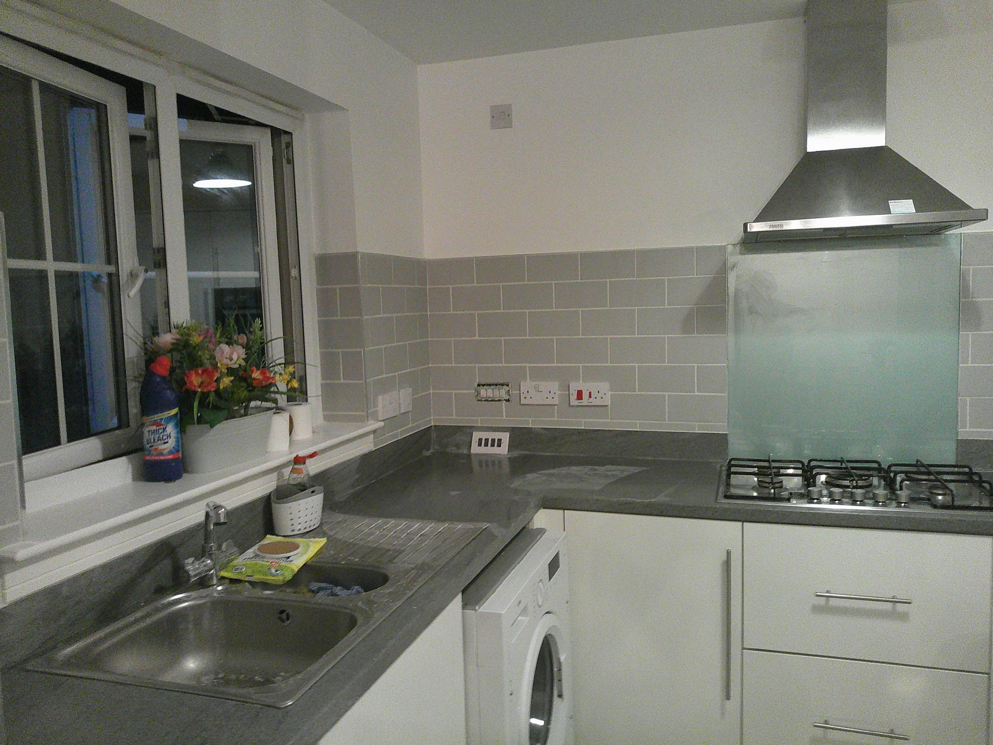 Finished grey brick-style tiled splashback around the sink and window in Whitburn
