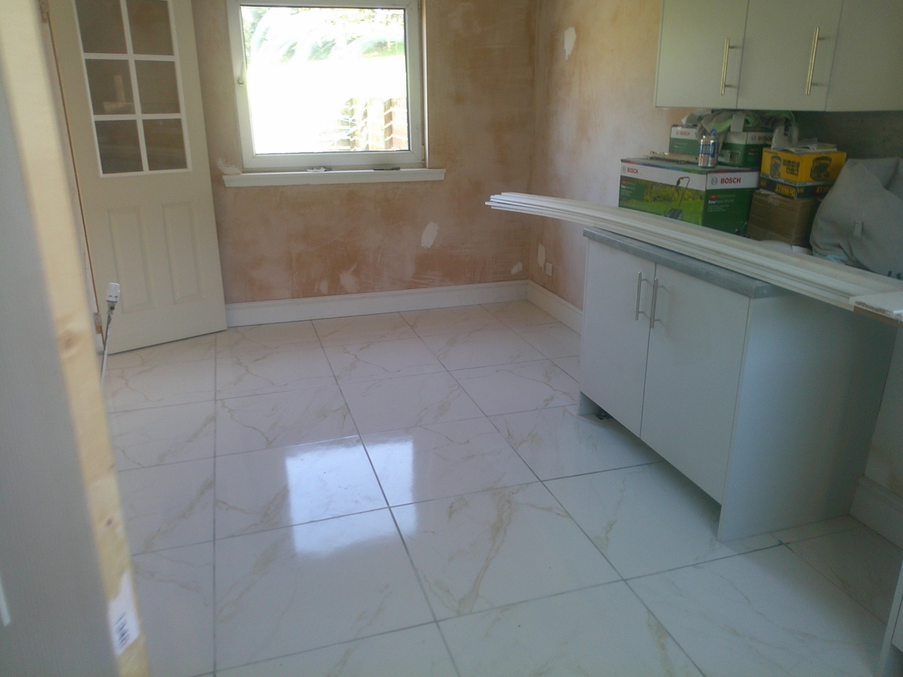 Finished large-format marble-effect floor tiling in adjoining room in East Kilbride
